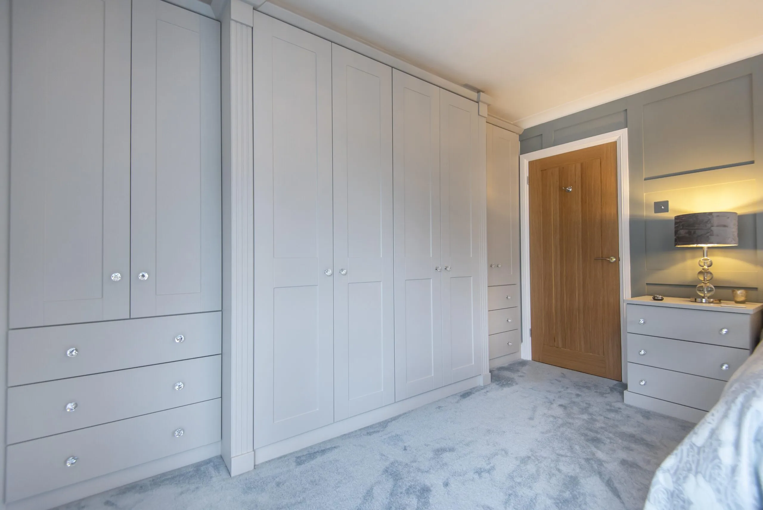 Main cottage bedroom with fitted light grey wardrobes